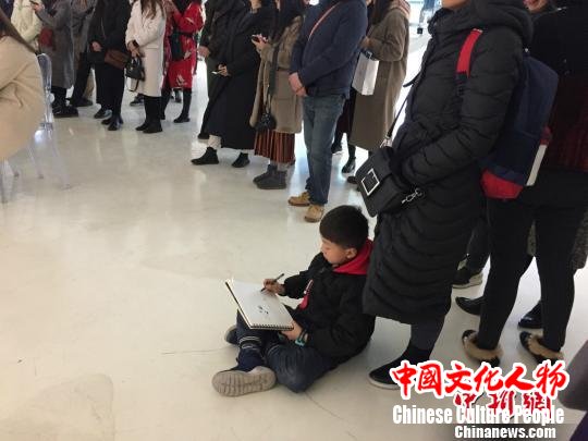 图为展览现场,一名小朋友认真做记录。 钟欣 摄 图为展览现场,一名小朋友认真做记录。 钟欣 摄