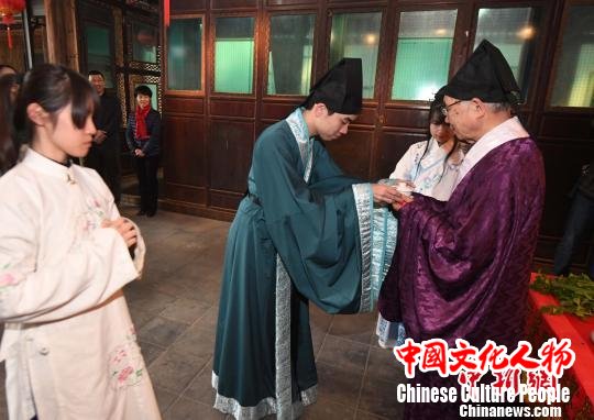 身着汉服的两岸青年学生按传统，共同向福州民俗专家郑子端行拜师礼仪。　记者刘可耕 摄