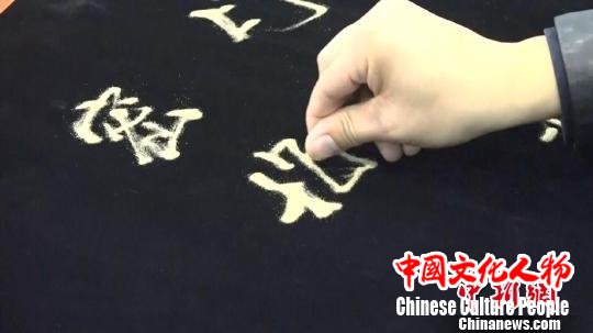 王修雷展示传统的沙书技艺 张俊 摄